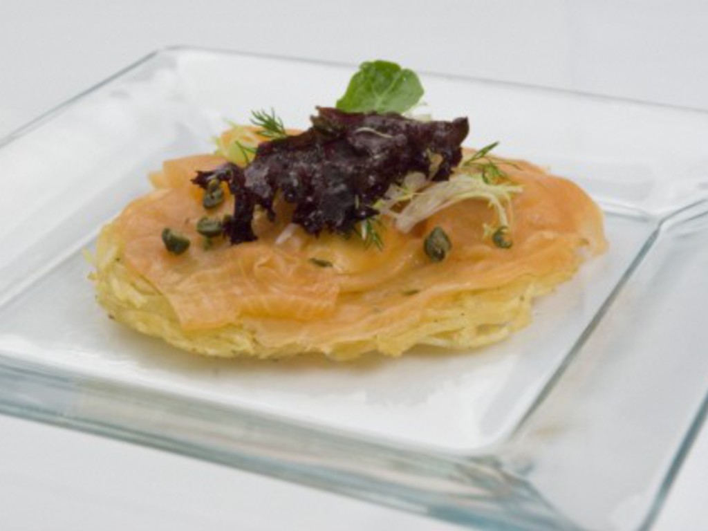 Salmone affumicato su una galletta di patate, creme fraiche e insalatine miste.
