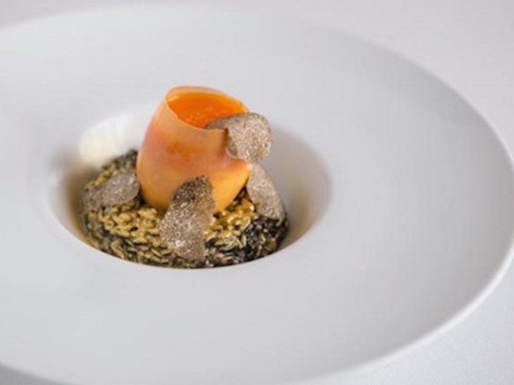 Uovo di cristallo ripieno di morbido di albume, parmigiano e patata, con il suo tuorlo su riso nero, oro e tartufo bianco.   