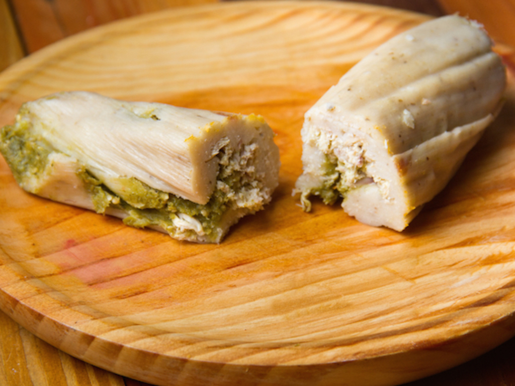 Tamales di mais con carne di maiale in salsa di pomodori verdi